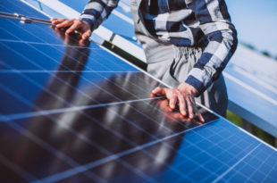 Man worker in the firld by the solar panels